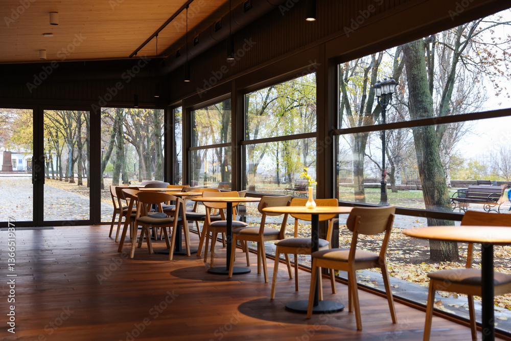 Fototapeta premium Stylish restaurant with large windows and comfortable furniture. Interior design
