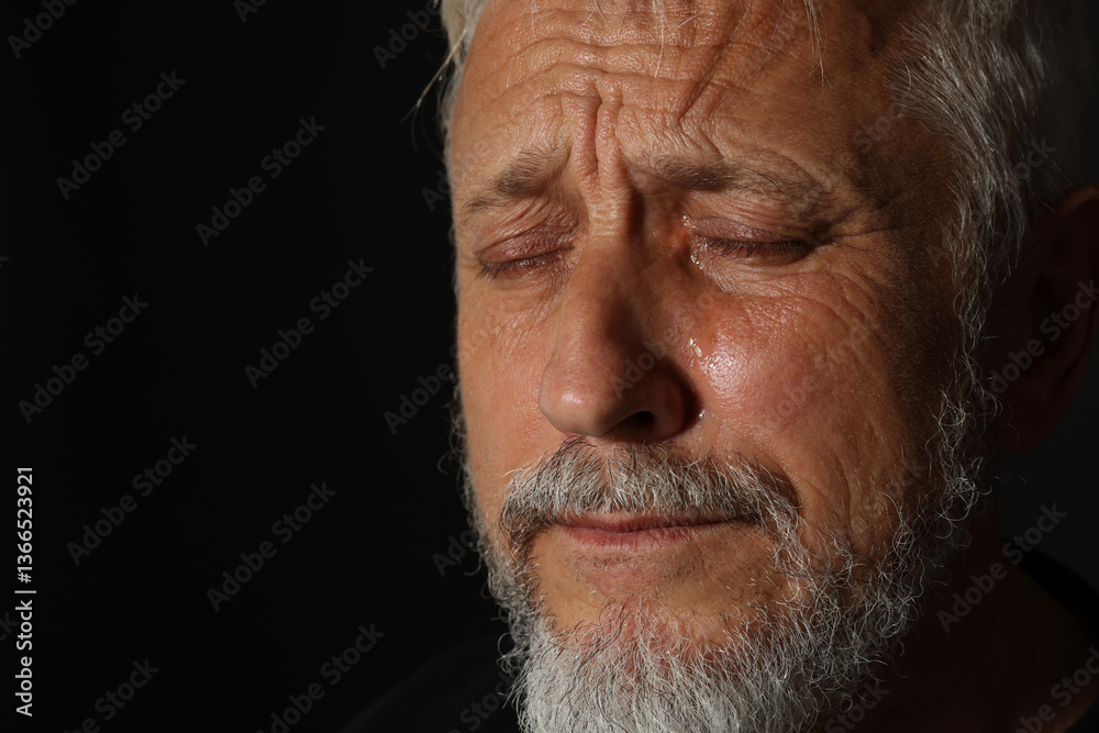 Obraz premium Sad senior man crying on black background, closeup. Space for text