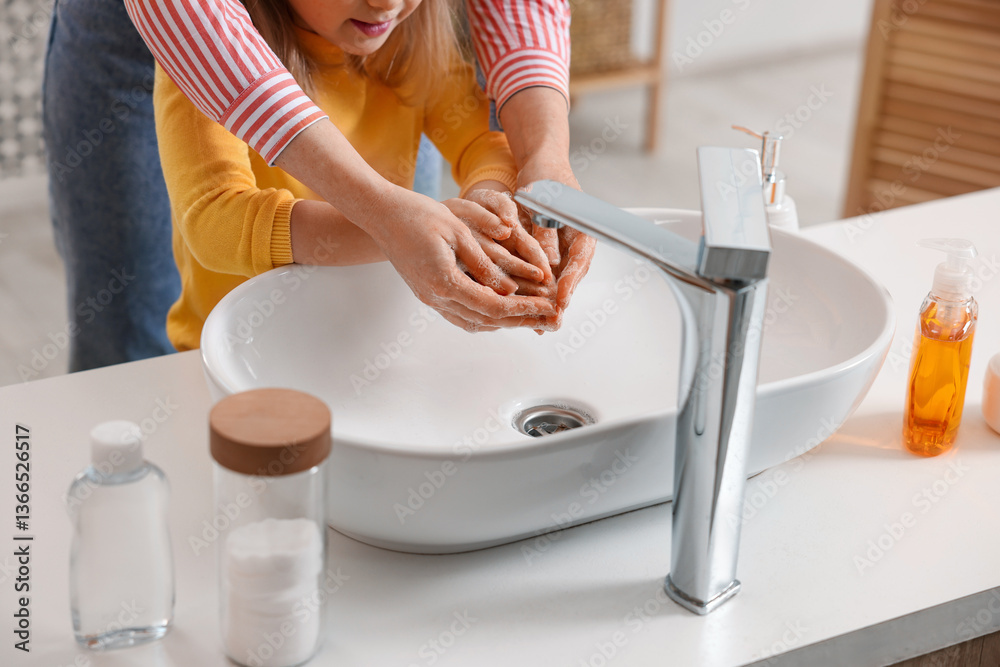 Mother and daughter washing their hands indoors, closeup Mother and daughter washing their hands indoors, closeup