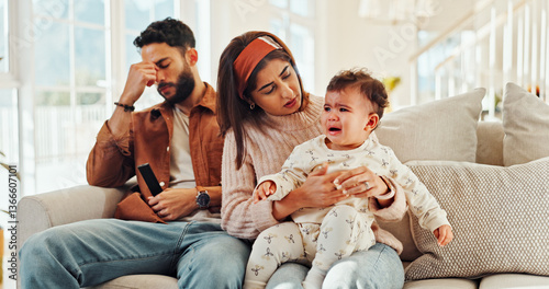 Family, man and woman with baby, crying and stress for new parents with child, lounge and home. Noise, father and annoyed by interruption from game, thinking or mother with emotional toddler in house