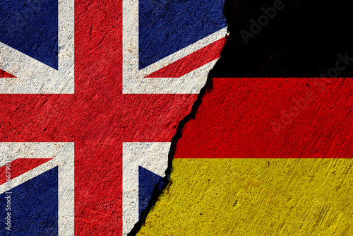 cracked concrete wall with painted united kingdom and germany national flags, economical or political relations concept