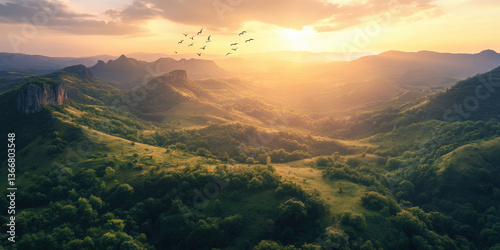 Golden hour over mountain landscape with birds flying in formation