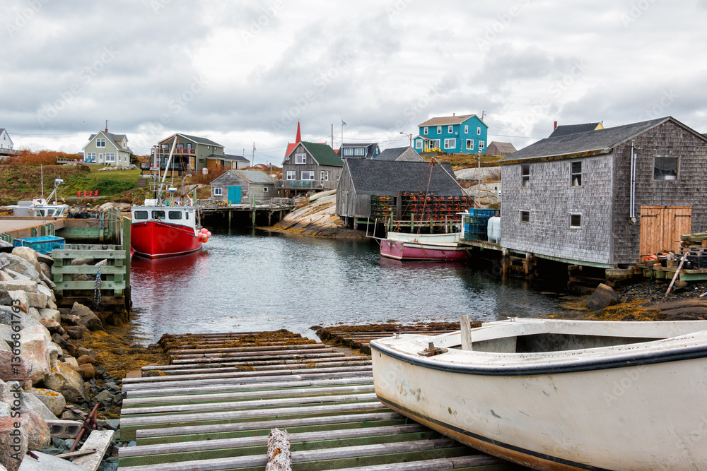 Fototapeta premium Quaint lobster fishing village of Peggy's Cove, near Halifax, Nova Scotia, Canada. Small boat launch area with fishing boats and lobster traps during a cloudy autumn day.