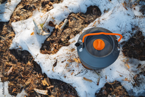 Wallpaper Mural A bright, cheerful tea kettle featuring an orange handle sits prominently atop a large, fluffy pile of pristine, white snow, creating a vivid contrast in color and texture Torontodigital.ca