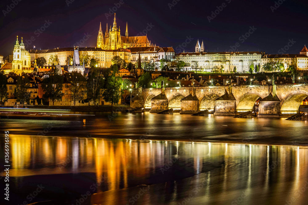 Obraz premium This enchanting night view of Prague, Czech Republic, features the illuminated Prague Castle as a focal point, with the historic Charles Bridge