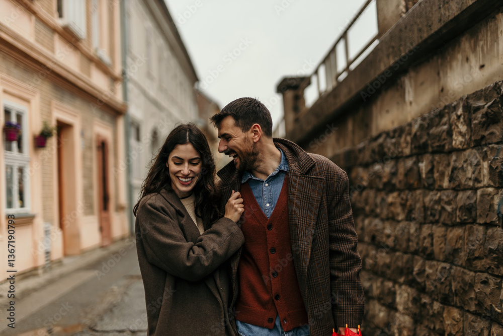 Happy couple laughing and walking on a city street Happy couple laughing and walking on a city street