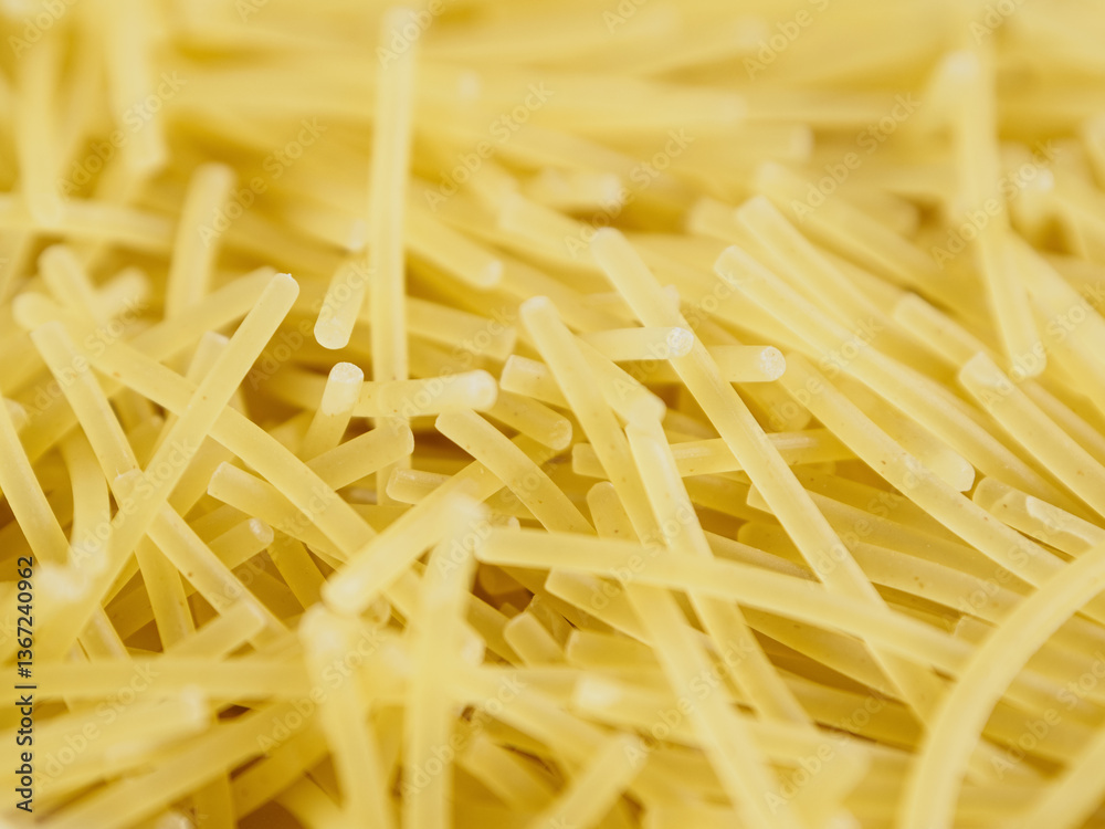 Close-up of small, thin vermicelli filini pasta. Delicate strands create a fine, textured food background. Close-up of small, thin vermicelli filini pasta. Delicate strands create a fine, textured food background.