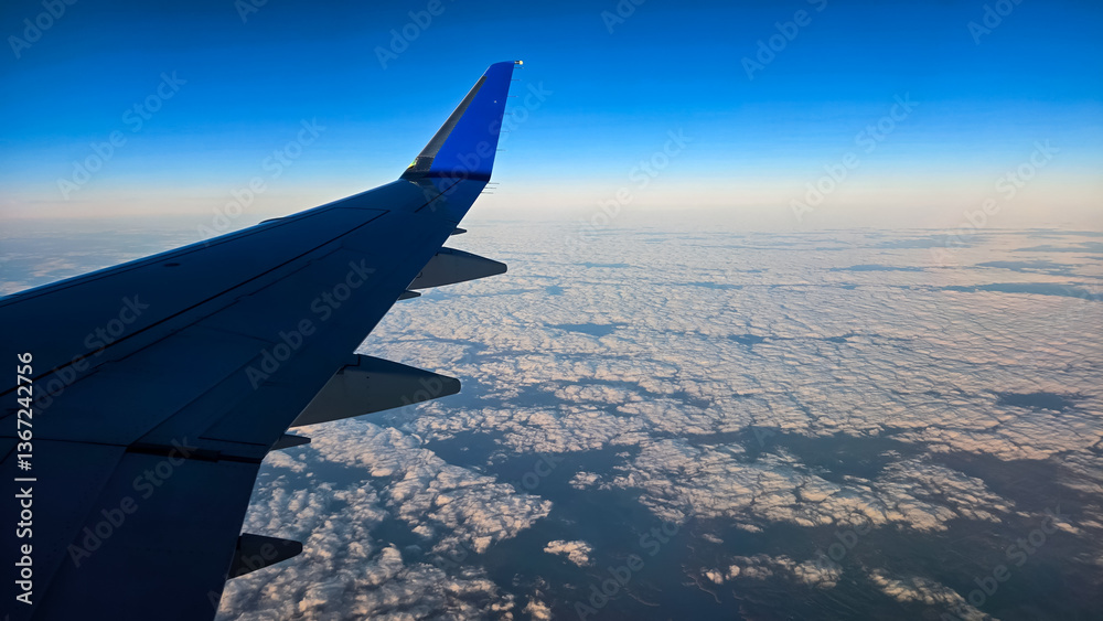 Obraz premium Looking out of an Airplane Window at Sunset while in Flight