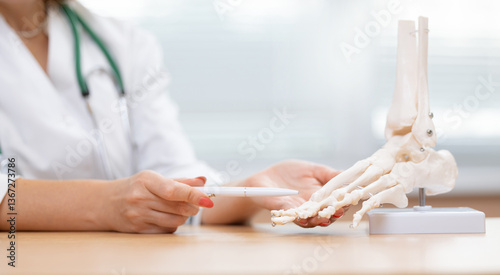Cuadro en lienzo Female rheumatologist doctor explaining foot anatomy with skeletal model in medi