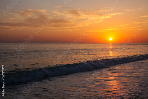 Photography beautiful and colorful sunset, warm light and many clouds, sea waves on the sea