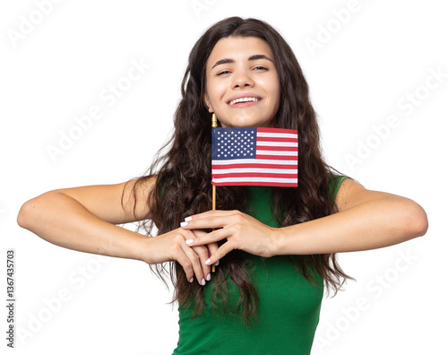 A young happy girl with a smile on her face holds an American flag in her hands. Symbol of patriotism and freedom.
