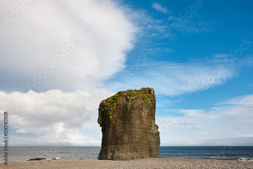 Picturesque rock on a pebble beach. East fjords coastline. Iceland
