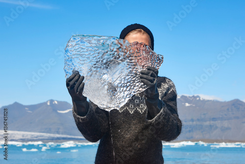 Obraz na płótnie Block of ice held by a young woman. Jokulsarlon, Iceland. w salonie