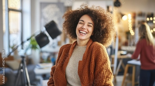 Woman artist smiling in vibrant creative studio setting.