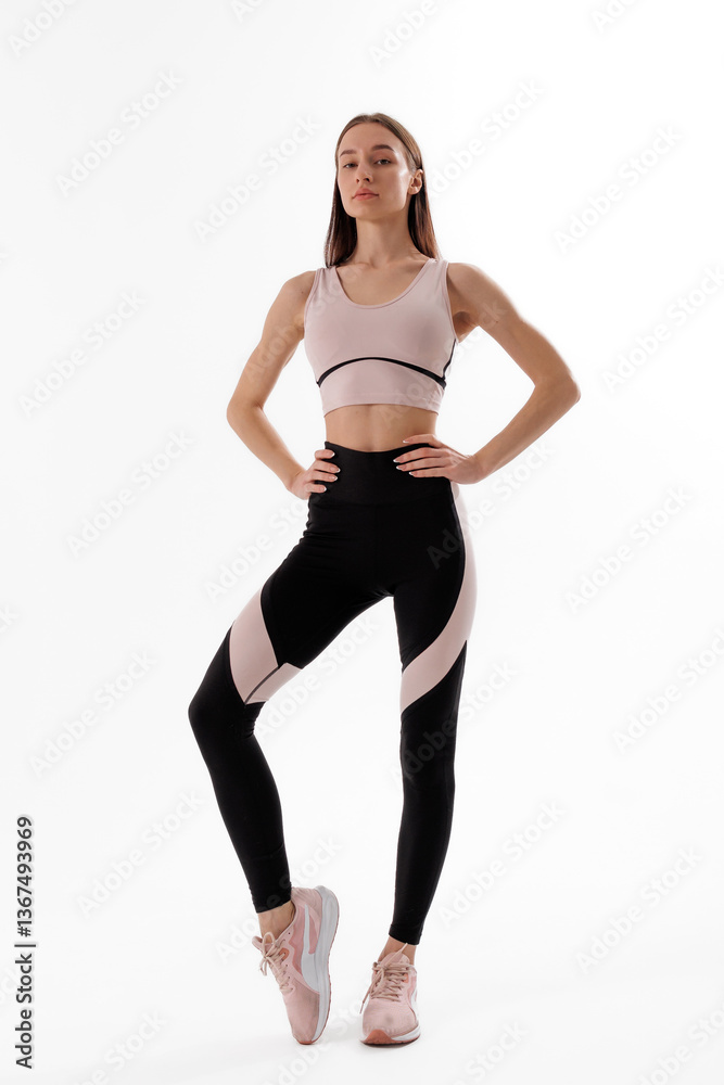 Young woman poses confidently in athletic wear showcasing fitness lifestyle during a studio session Young woman poses confidently in athletic wear showcasing fitness lifestyle during a studio session