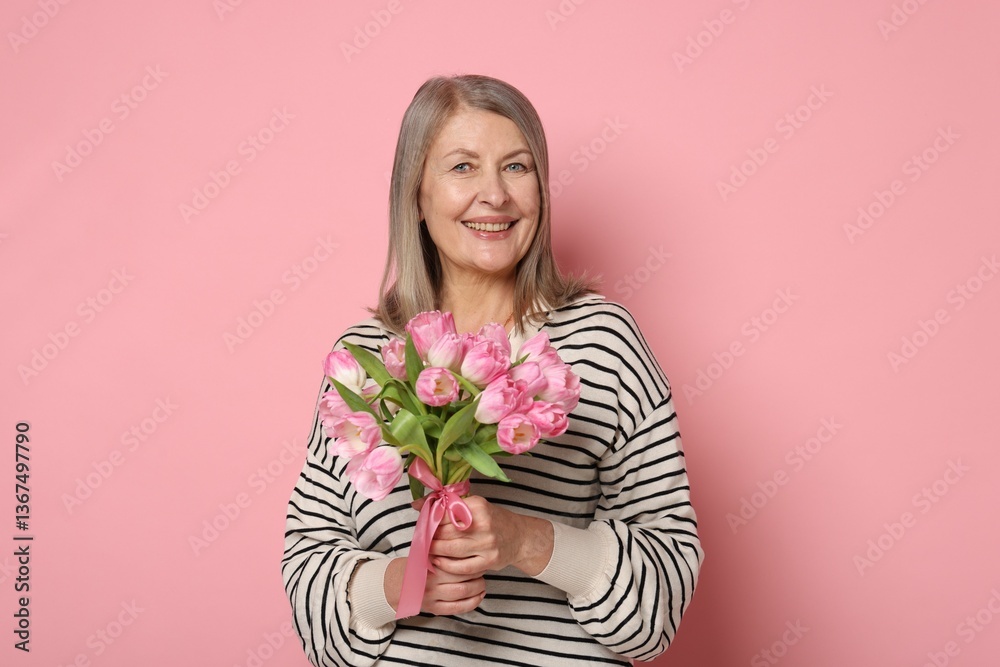 Smiling woman with bouquet of tulips on pink background Smiling woman with bouquet of tulips on pink background