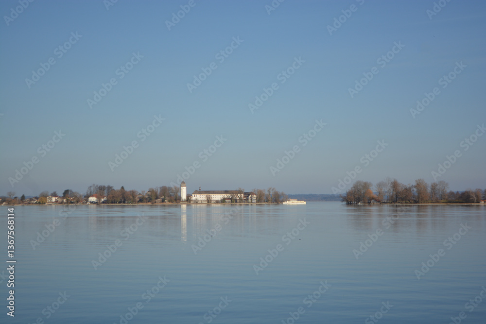 Fototapeta premium Fraueninsel, Frauenchiemsee on lake Chiemsee in the morning sunrise with boat, Sailboat, church, monastery. Bavaria, Bayern, Germany