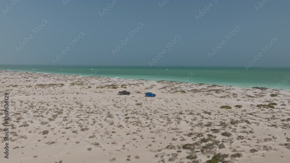 Two cars driving along a remote beach in Bar Al Hikman, Oman, peaceful and free Two cars driving along a remote beach in Bar Al Hikman, Oman, peaceful and free