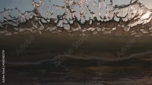 Dramatic ocean waves at sunset reflect golden light in tranquil seascape journey