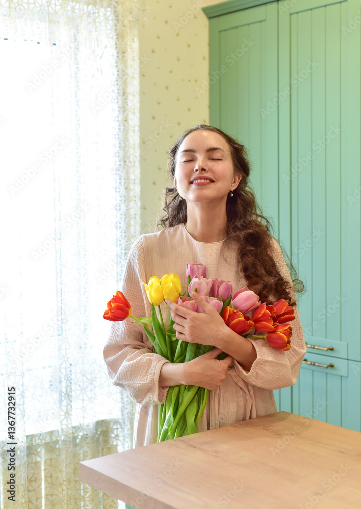 Beautiful young woman with tulip bouquet. Spring portrait. At home interior. Mother's Day. Springtime Beautiful young woman with tulip bouquet. Spring portrait. At home interior. Mother's Day. Springtime