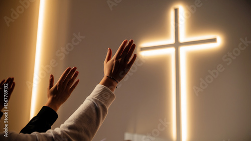 Raised hands towards illuminated cross, showcasing faith, hope, and spirituality in a religious setting, symbolizing prayer and devotion