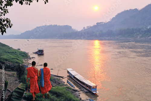 Monks at sunset on Mekong River at Luang Prabang, Laos