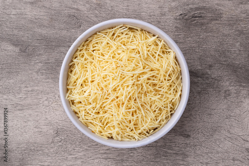 Potato straw or shoestring potato in a bowl over wooden table