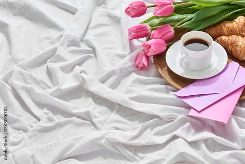 A warm bed scene for Mother’s Day, showcasing a lovely breakfast tray with fresh pink tulips, a cup of coffee, croissants, and colorful greeting cards, celebrating love and gratitude.