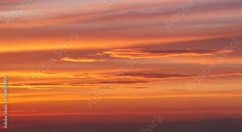 Vibrant sunset with colorful clouds over a serene landscape, evoking peace and tranquility