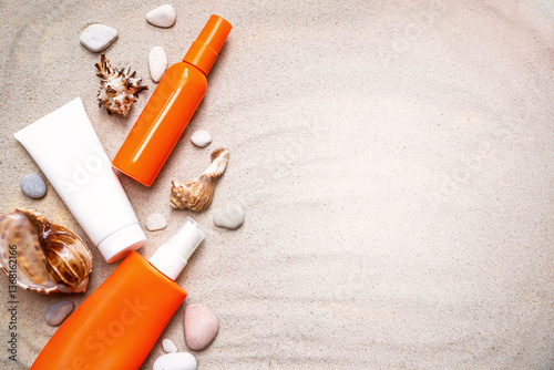 Bottles of sunscreen (sun cream)  on the sand background with seashells.  Sun tan, summer skin care, photoaging,  skin health, UV protection. Copy space. Empty place .