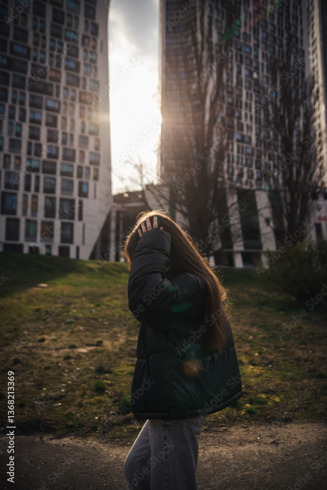 Naklejka premium Stylish young woman in a black jacket on a city street on a cool day