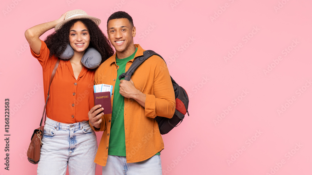 Obraz premium Happy black couple with passports and backpack posing over pink studio background, smiling at camera, ready for trip, panorama with free space