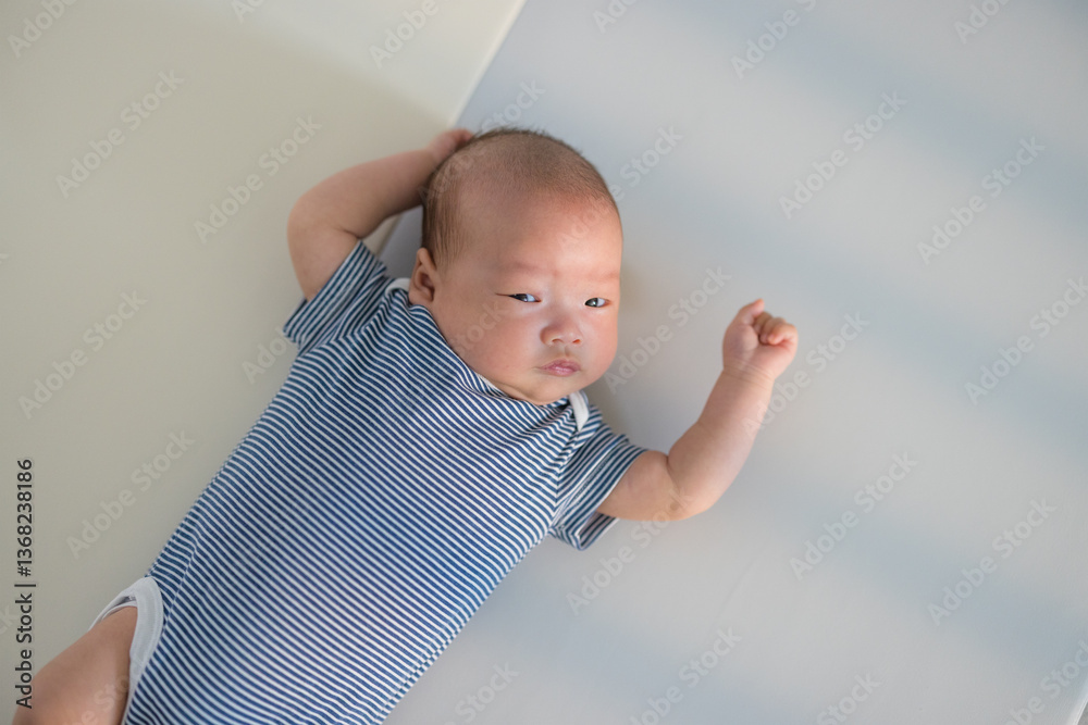 Adorable baby boy resting on white surface