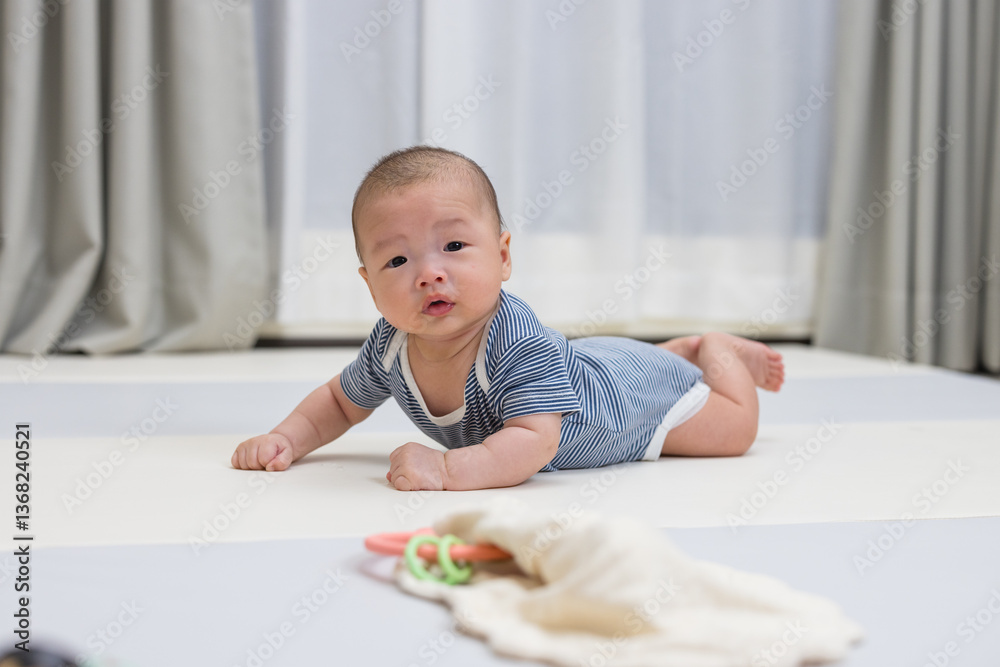 Cute newborn baby learning to crawl on mat