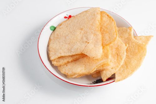 A bowl of Krupuk Udang (prawn crackers), a crispy Indonesian snack.  it's a savory and popular appetizer. photo