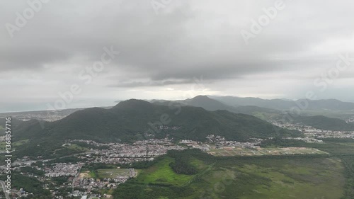 Stunning aerial view reveals lush landscapes and hills in cloudy atmosphere