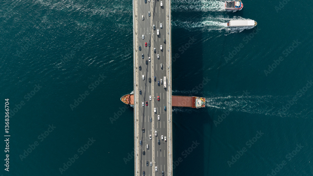 Tanker ship passing under the FSM Bridge with a heavy car traffic on the bridge.Aerial view of The Second Bosphorus Bridge or Fatih Sultan Mehmet Bridge, Istanbul. Tanker ship passing under the FSM Bridge with a heavy car traffic on the bridge.Aerial view of The Second Bosphorus Bridge or Fatih Sultan Mehmet Bridge, Istanbul.