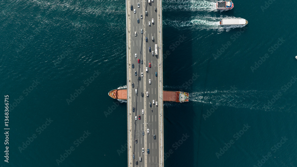 Tanker ship passing under the FSM Bridge with a heavy car traffic on the bridge.Aerial view of The Second Bosphorus Bridge or Fatih Sultan Mehmet Bridge, Istanbul. Tanker ship passing under the FSM Bridge with a heavy car traffic on the bridge.Aerial view of The Second Bosphorus Bridge or Fatih Sultan Mehmet Bridge, Istanbul.