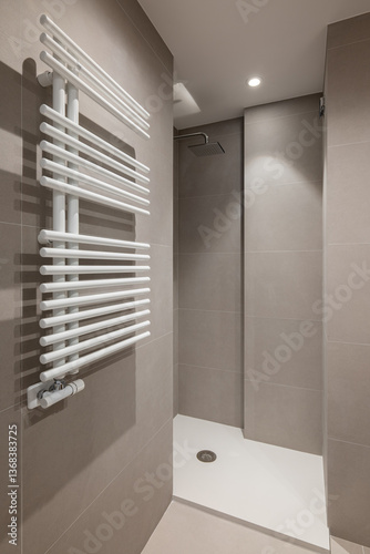 Modern shower with white towel radiator and minimalist tiled design