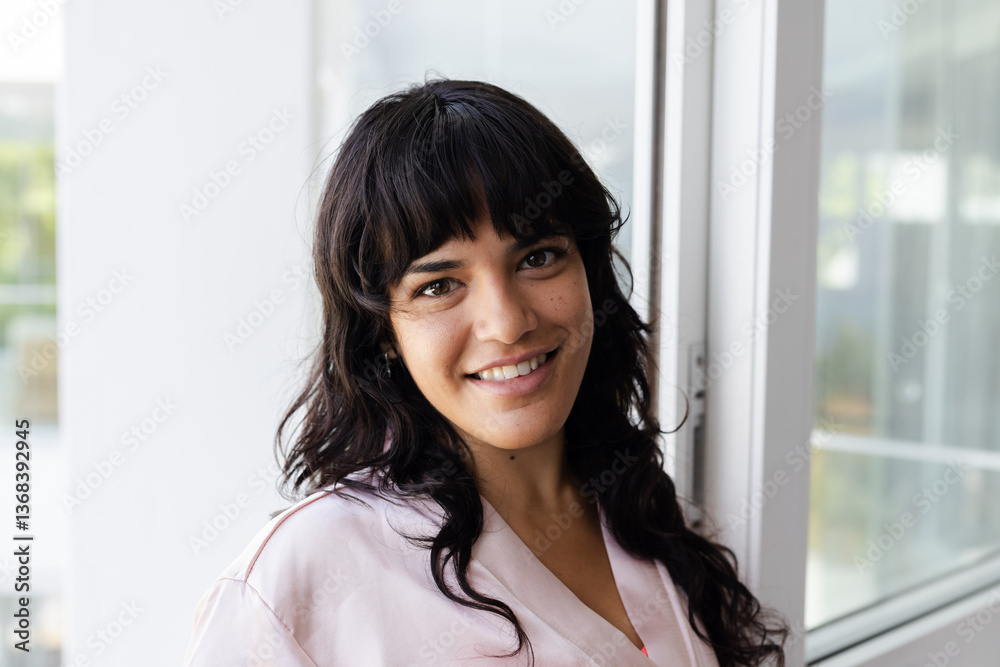 Smiling woman standing by window, enjoying natural light at home, at home Smiling woman standing by window, enjoying natural light at home, at home