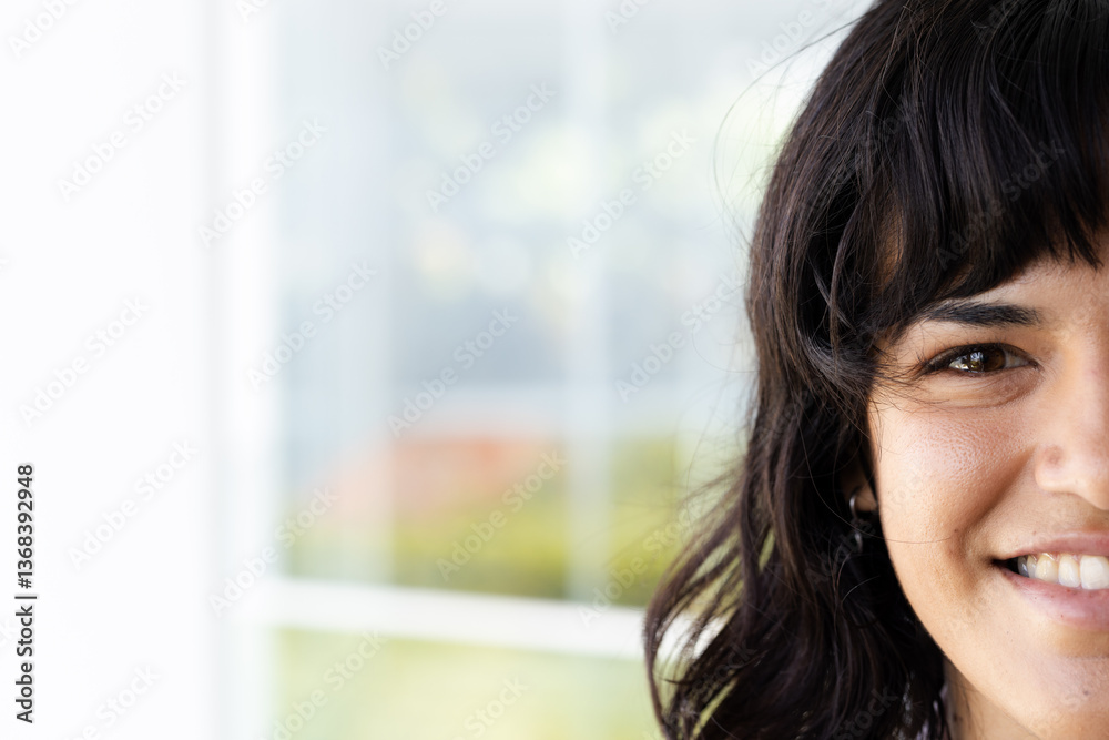 Smiling woman with dark hair sitting by window, enjoying sunny day, at home, copy space Smiling woman with dark hair sitting by window, enjoying sunny day, at home, copy space