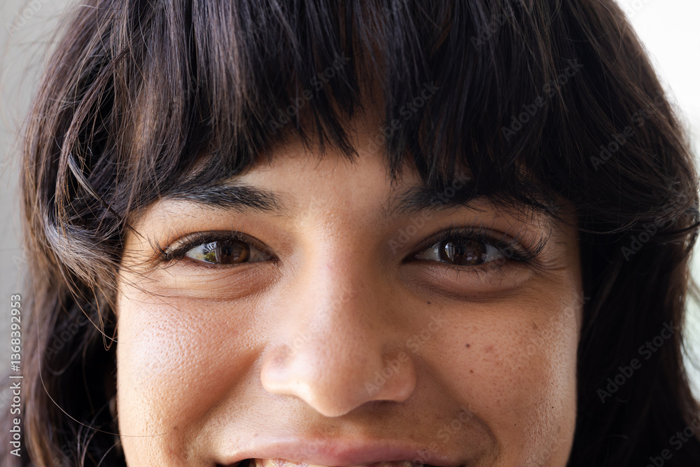 Smiling woman with dark hair looking directly at camera, showing happiness, at home Smiling woman with dark hair looking directly at camera, showing happiness, at home