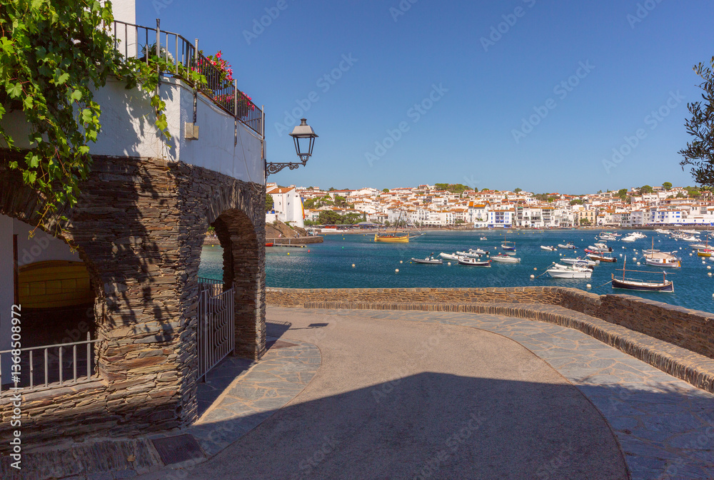 Boats anchored in the harbor of Cadaques with white buildings in Spain