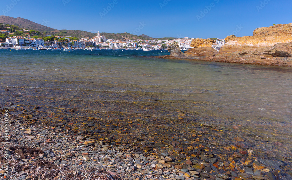 Shallow coastal water and boats facing Cadaques village in Spain