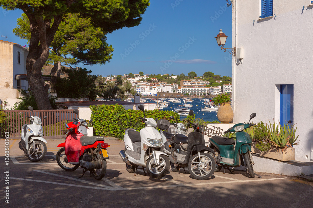 Boats anchored in the harbor of Cadaques with white buildings in Spain