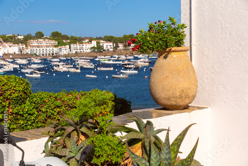 Boats anchored in the harbor of Cadaques with white buildings in Spain