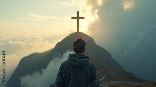 Man facing cross on mountain peak representing faith, religion, and spirituality concept