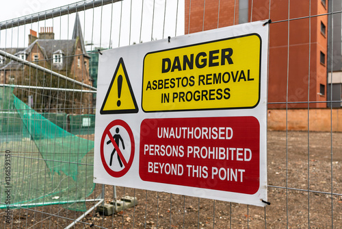 Construction Site Attention Danger Asbestos Removal and Demolition in Progress Sign on Temporary Heras Fence Panel with Blurred Background Buildings photo