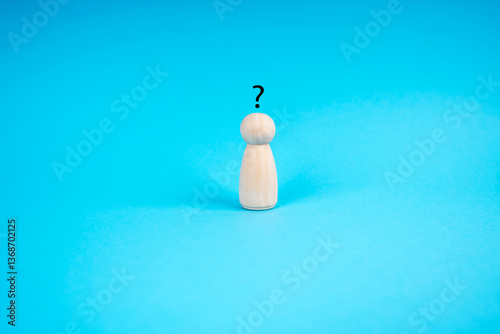 Human wood figurine with Question Mark on blue background. Curiosity, the desire to learn concept