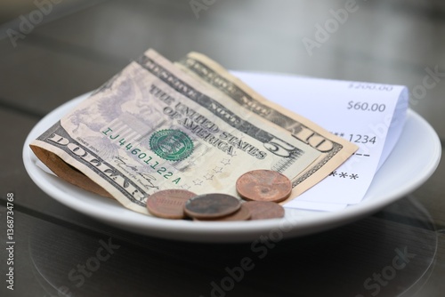 Photos Tip and receipt on wooden table in cafeteria, closeup